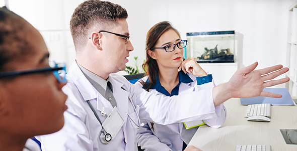 Doctors discussing an issue using a computer as visual aid